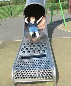 This boy seems utterly scared for dear life landing on the cheese grating slide. Perhaps he didn't see where he'd land before going down the slide.