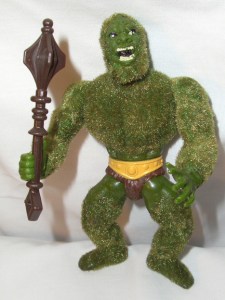 Comes with his own club and speedo. And yes, he's supposed to be a bacteria grabbing walking carpet as if he was a lovechild between the Incredible Hulk and the Grinch. Also said to have "a real pine scent." Creepy.