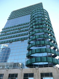 This is the Clal Insurance Building in Tel Aviv, Israel. Nevertheless, I'm not sure if the green rings go well with the glittery glass windows. But that's just me.