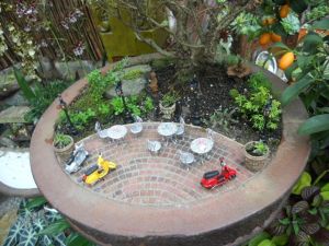 Now this is a miniature garden containing a small patio with scooters. Still, it's quite creative and probably made by someone with too much time on their hands.
