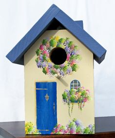 Now this is a lovely little birdhouse I wouldn't mind having in my yard. It seems so picturesque, especially the floral wreath around the hole.