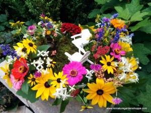 Now this garden contains a lot of flowers you'd see in any regular garden during the summer. Yet, it's considered as such because of the two little lawn chairs and that it's in a pot.
