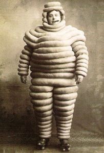 And he's smoking a cigar, lovely. Now Michelin was founded in 1889 and the Michelin Man has been around since 1898. So it's probably possible that such Michelin Man costume existed at the time.