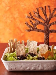 Now I'm sure the dip is under the olives and lettuce. Still, I have to admire how this person used the tortilla chips for the gravestones, tree, and cat.