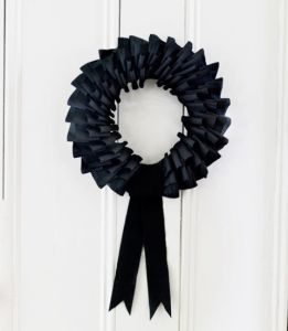 Now this wreath seems mostly laced with black streamers. Also, resembles a wreath you'd expect to see in a funeral home.