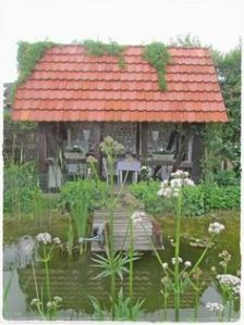 This one has a red shingle roof. Also has some vines growing on it. Lovely.