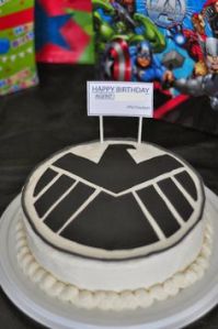 Now we know the kind of cake someone should get for Nick Fury's birthday party. After all, even though S.H.I.E.L.D. is a secret organization, its logo appears everywhere.