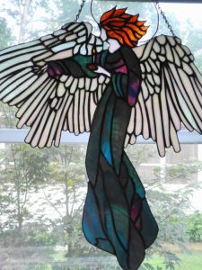 Must be a guardian angel motif. But this one has brilliant wings and an iridescent gown.