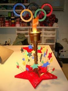 Features Olympic rings and a light up torch. Also has stars on the bottom. Love it.