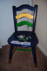 This is a wooden chair painted with Notre Dame colors. And yes, the Fightin' Leprechaun is in the seat.