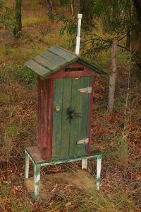 Because this mailbox apparently resembles an old wooden outhouse. And it has a spider on it.