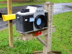 Okay, this is a Nikon camera mailbox made from wood. Guess the mail comes in from the side.