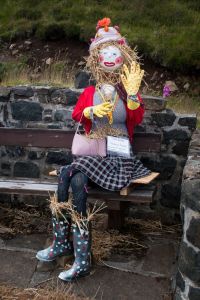 She's just sitting on the bench. Too bad she has straw in her boots. Then again, she's a scarecrow.