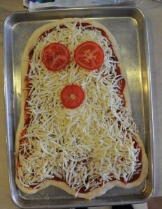 It even has tomato eyes and mouth as well as is covered in cheese. Yes, this is pure Halloween gold.