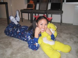 She's dressed in a footie pajama outfit with pigtails. Also has her Care Bear to snuggle with.