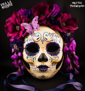 This one is painted like a skull with a wide array of purple feathers and flowers. Like the purple butterfly.