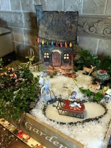 This one has lights on the house as well as candy canes and a sled on a frozen pond. Like the wreath on the table.