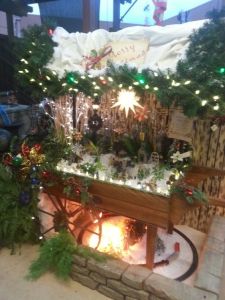 This one has a whole village with a train below and lighted garland roof. Not to mention, you have to love the lighted star.