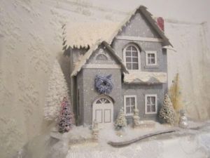 This is a blue sparkly house with a wreath and trees around it. Love it.