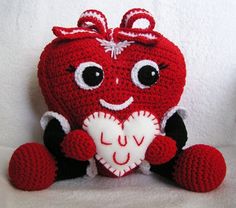 Here the heart is holding a cute little valentine. Love the bow on the head. Adorable.
