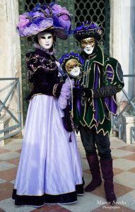 I can see that both are dressed in black and purple. Love the woman's hat.