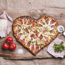 heart-shaped-pizza-and-ingredients-on-cutting-board-royalty-free-image-1579107262